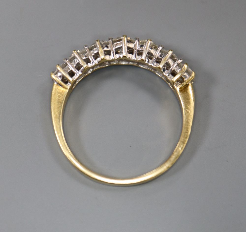 A modern 18ct gold and graduated seven stone diamond half hoop ring, size P, gross 3.6 grams.